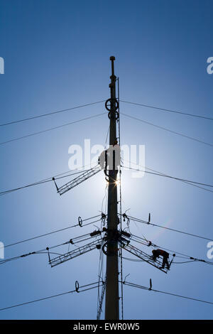 La réparation d'un travailleur de l'industrie de l'énergie haute tension d'alimentation de la ligne. Pas de visage est visible. Super pour l'énergie, de sécurité et de technologie thèmes Banque D'Images