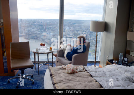 Femme à l'aide d'un téléphone tout en regardant la vue de l'hôtel Shangri-La's d'échardes Banque D'Images