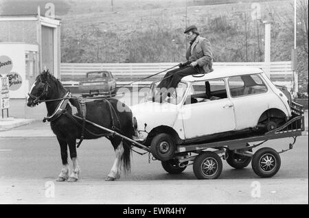 Un rag and bone man at les rênes de son cheval et panier ramène les restes d'un mini trouvés dans les rues d'une ville du nord sans nom Février 1982 Banque D'Images