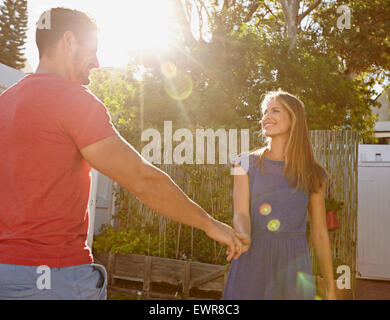 Tourné en plein air de belle jeune couple holding hands and smiling. Plein soleil avec s Banque D'Images