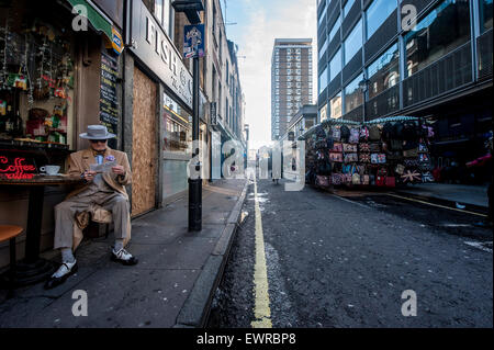 Un homme très habillé (Soho George) lit dans un café Soho dans le centre de Londres Banque D'Images