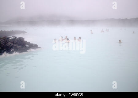 Les touristes au Blue Lagoon Spa en Islande par temps froid brumeux Banque D'Images