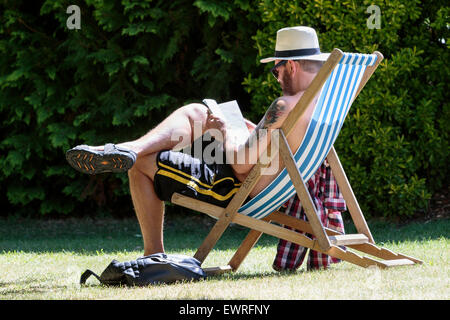 Bath, Royaume-Uni, le 30 juin, 2015. Un homme aime la chaleur du soleil pendant qu'il lit un livre à Bath's Parade Gardens comme privé prévoient que le beau temps se poursuivra et que demain peut être la journée la plus chaude de l'année jusqu'à présent. Credit : lynchpics/Alamy Live News Banque D'Images