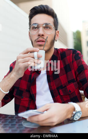 Outdoor portrait of entrepreneur de boire du café concentré dans quelque chose. Banque D'Images