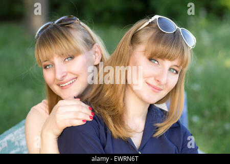 Deux jolies femmes s'amusant parc d'été. Les filles sont des jumeaux posant à la à l'appareil photo Banque D'Images