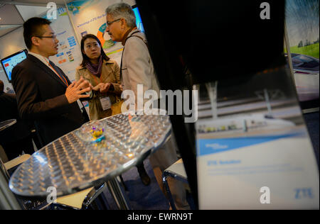 (150630) -- JOHANNESBURG, 30 juin 2015 (Xinhua) -- un membre du personnel (L) introduit des produits ZTE à un client (R) sur le stand de l'Afrique au cours de ZTE 2015 Rail au Sandton Convention Centre de Johannesburg, Afrique du Sud, le 30 juin 2015. L'édition 2015 de la plus grande exposition de transport qui comprend : l'Afrique des transports ferroviaire, aérien, les ports de l'Afrique de l'Afrique Festival et montrer le port, la sécurité des transports et de la sécurité et de l'Afrique montrent la cargaison montrent l'Afrique, a ouvert ce mardi. Environ 150 exposants mondial participent à l'événement de deux jours, qui aide les opérateurs de transport, les investisseurs et leurs partenaires à t Banque D'Images