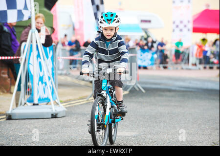 Cycles de jeune garçon vers la caméra au cours d'une épreuve cycliste amateur d'enfants en Grande-Bretagne Banque D'Images