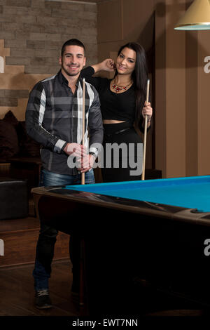 Portrait d'un jeune couple jouant au billard Banque D'Images