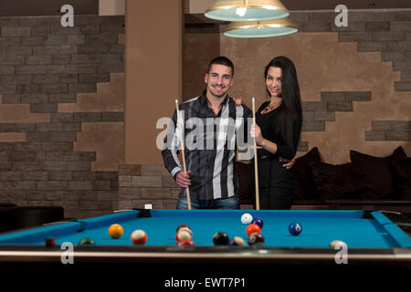 Portrait d'un jeune couple jouant au billard Banque D'Images