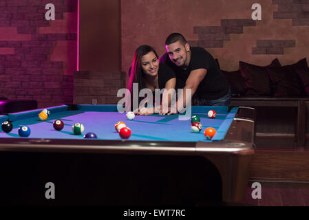 Young Caucasian Woman qui reçoivent des conseils sur la prise de vue extérieure boule tout en jouant au billard Banque D'Images