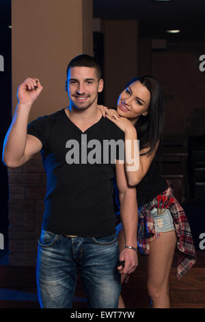 Jeune couple jouant un jeu de fléchettes Tir Banque D'Images