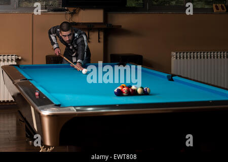 Jeune homme doublure pour balle frappée sur Table de billard Banque D'Images