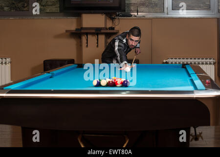 Jeune homme doublure pour balle frappée sur Table de billard Banque D'Images