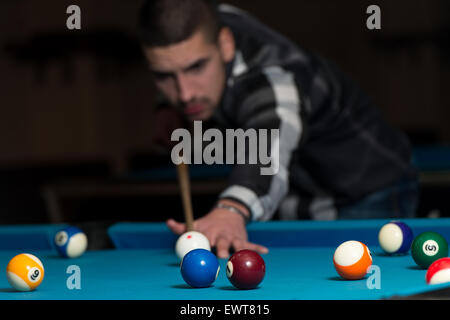 Jeune homme doublure pour balle frappée sur Table de billard Banque D'Images