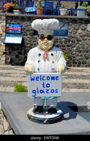 Un mannequin d'un chef tenant une pancarte pour une taverne. Santorini Grèce. Banque D'Images