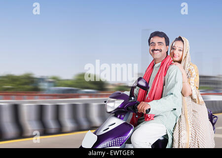 2 Couple marié rurales indiennes road Riding Scooty Banque D'Images