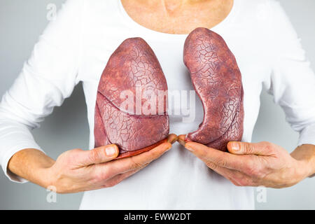 Femme montrant modèles de deux poumons en face de la poitrine pour symboliser la respiration pour l'éducation Banque D'Images