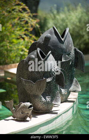 Danse asiatique en bronze des statues du poisson au bord de la piscine Banque D'Images