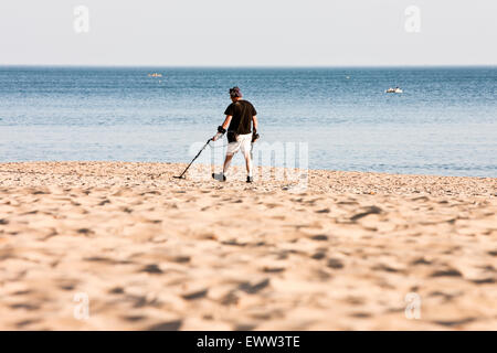 Sur une journée de printemps ensoleillée, un detectorist, détecteur de métal, à l'aide d'après la plupart des touristes et vacanciers ont quitté beach vous recherchez/treasure Banque D'Images