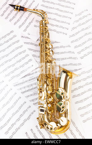 Saxophone alto brillant en pleine grandeur sur les notes de musique Banque D'Images