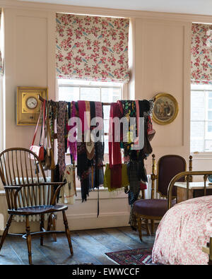 Foulards assortis accrochées sur un rack de vêtements chinois dans une chambre avec des stores à motifs floral et président de Windsor Banque D'Images