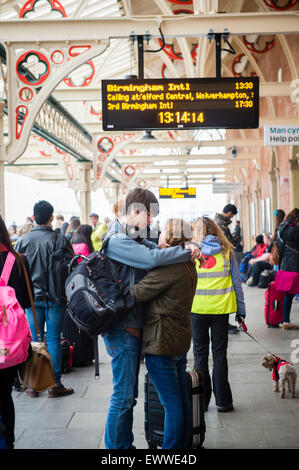 La maison pour l'été : un jeune couple homme femme garçon fille étudiants universitaires car ils attendent leur train dans la foule du quai à la fin de l'année scolaire : la gare d''Aberystwyth, Pays de Galles, Royaume-Uni Banque D'Images