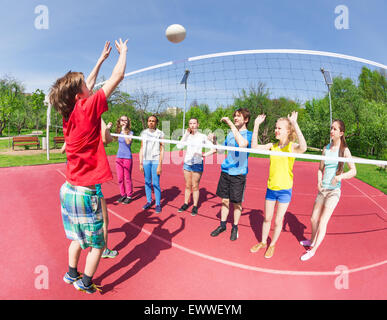 Garçon active et les filles jouer au volley-ball ensemble Banque D'Images
