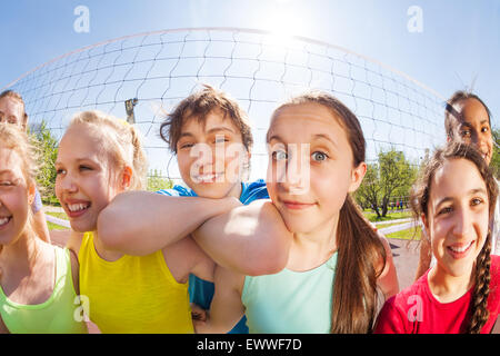 Les adolescents heureux en face de filet de volley-ball, close-up Banque D'Images