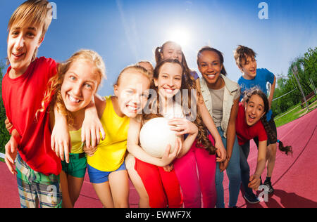Teens standing in hug sur la cour de jeu de volley-ball Banque D'Images