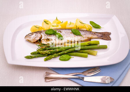 Truites grillées, pommes de terre au romarin, asperges vertes, Close up Banque D'Images