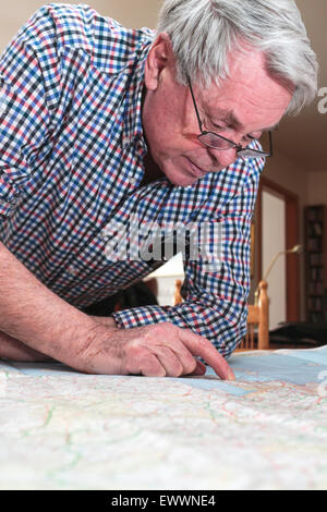 Citiizen Senior reading map avant de partir en vacances en Europe Banque D'Images