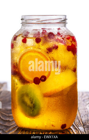 Pot de verre (spritzer maison schorle) avec du jus de pomme gazéifié servi avec des fruits congelés, les cubes de glace et les roues wild cranber Banque D'Images