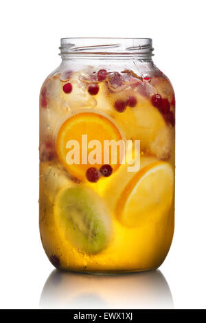 Pot de verre (spritzer maison schorle) avec du jus de pomme gazéifié servi avec des fruits congelés, les cubes de glace et les roues wild cranber Banque D'Images