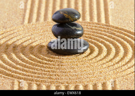 Jardin zen avec des pierres empilées dans le sable Banque D'Images