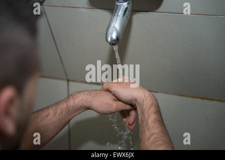 L'homme musulman se prépare à exercer dans la mosquée d'ablution Banque D'Images