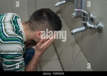 L'homme musulman se prépare à exercer dans la mosquée d'ablution Banque D'Images