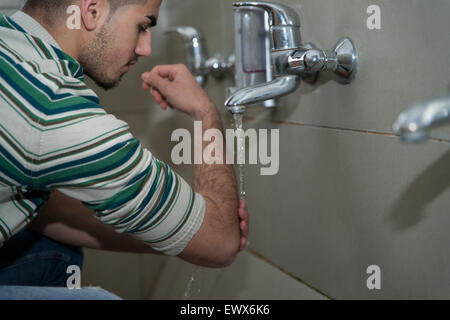 L'homme musulman se prépare à exercer dans la mosquée d'ablution Banque D'Images