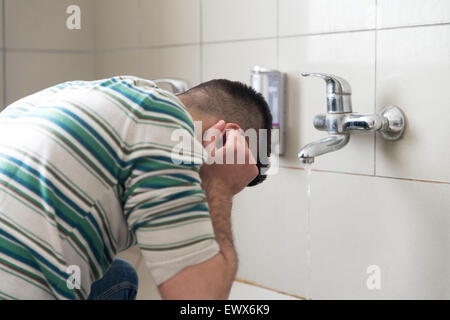 L'homme musulman se prépare à exercer dans la mosquée d'ablution Banque D'Images