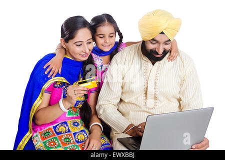 Les parents et la fille indienne Punjabi ordinateur portable achat en ligne par carte de crédit Banque D'Images