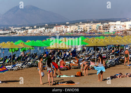 Une foule de gens, touristes se détendant sur la plage de sable Rethymno Crete Beach Grèce plage bains de soleil, vacanciers Banque D'Images