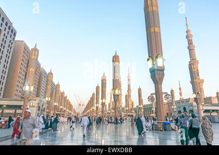 Les Pèlerins à pied sous les parasols géants à la mosquée Nabawi. Banque D'Images