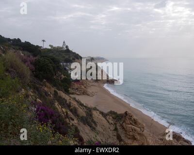 Plage vide en Espagne sur un sombre à la journée avec un phare surplombant les falaises Banque D'Images