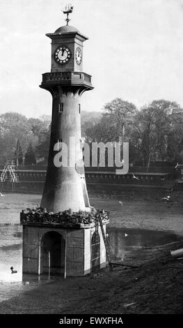 L'eau a été vidangée de Roath Park Lake pour le nettoyage d'hiver. Sur la photo est le phare dans le lac memorial à Roath Park. Le mémorial contient un modèle à l'échelle 'Terra Nova' ship pour commémorer le Capitaine Scott la voyage vers l'Antarct Banque D'Images