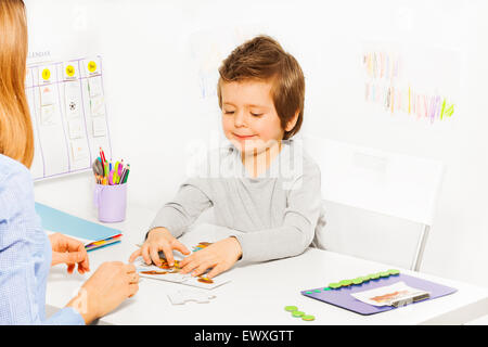 Smiling cute boy joue les jeu avec parent Banque D'Images