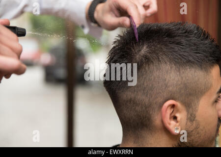 Beau jeune coiffure donnant une nouvelle coupe pour homme Client à Parlour Banque D'Images