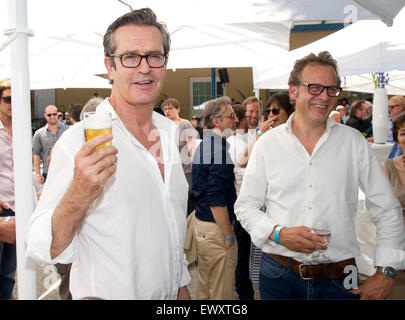 Munich, Allemagne. 07 juillet, 2015. L'acteur britannique Rupert Everett (L) est titulaire d'un verre de bière comme producteur Gilbert Moehler se tient derrière lui pendant un événement du FilmFernsehFonds (FFF) dans le cadre du 33e Festival du Film de Munich à Munich, Allemagne, 02 juillet 2015. Photo : Tobias HASE/dpa/Alamy Live News Banque D'Images