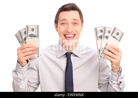 Joyful young man holding six piles de l'argent et regardant la caméra isolé sur fond blanc Banque D'Images