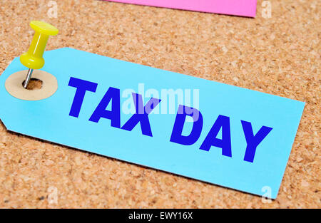 Une étiquette en papier avec les mots tax day écrit dessus, coincé avec un pouce tack sur un panneau de liège Banque D'Images