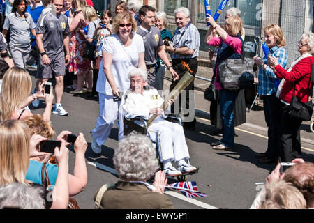 La flamme olympique de Londres 2012 sur le relais tour de UK avant Jeux Olympiques d'été. Ici, au centre de Glastonbury, Somerset dans le sud de l'Angleterre. À cette étape de la flamme portée par femme âgée en fauteuil roulant. 22 mai, 2012. Banque D'Images