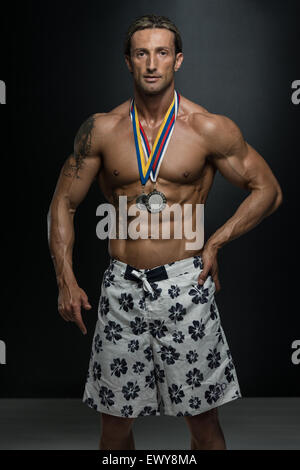 Fitness homme montrant son concurrent Médaille gagnante Banque D'Images